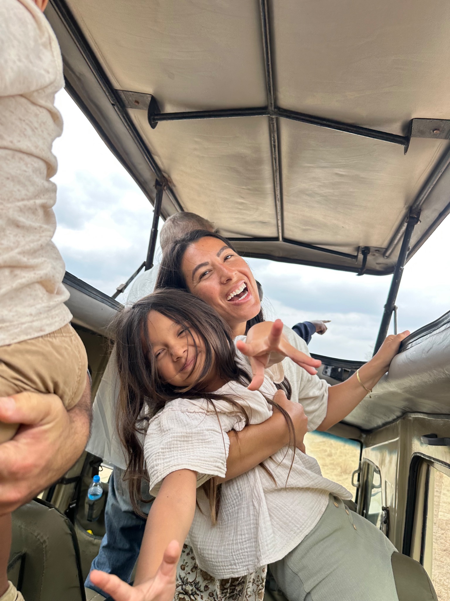 A mother and child laughing together inside a safari vehicle